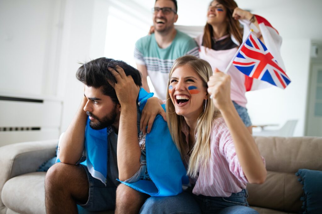 Group of football fans disappointed and happy watching a football game on the couch